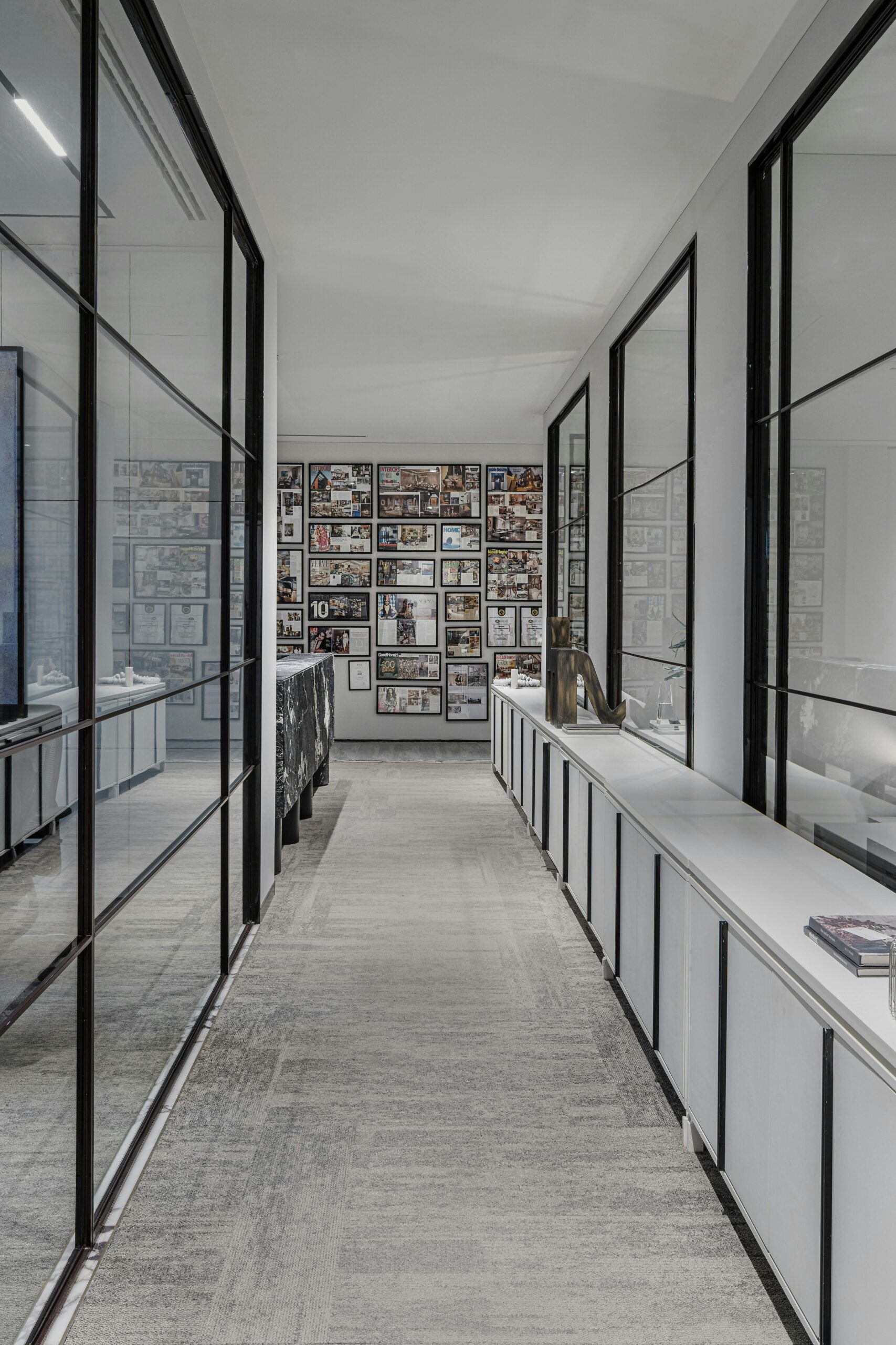 Sleek office hallway with glass walls and framed pictures. Ideal for corporate settings.
